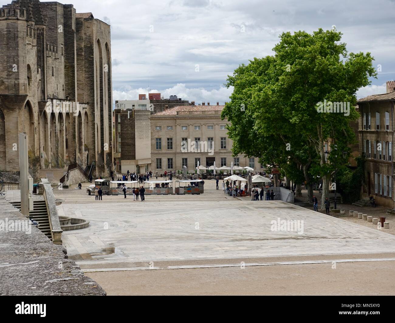 Matin sur l'esplanade en face de la palais des Papes avec quelques personnes et le petit train touristique, Avignon, France Banque D'Images