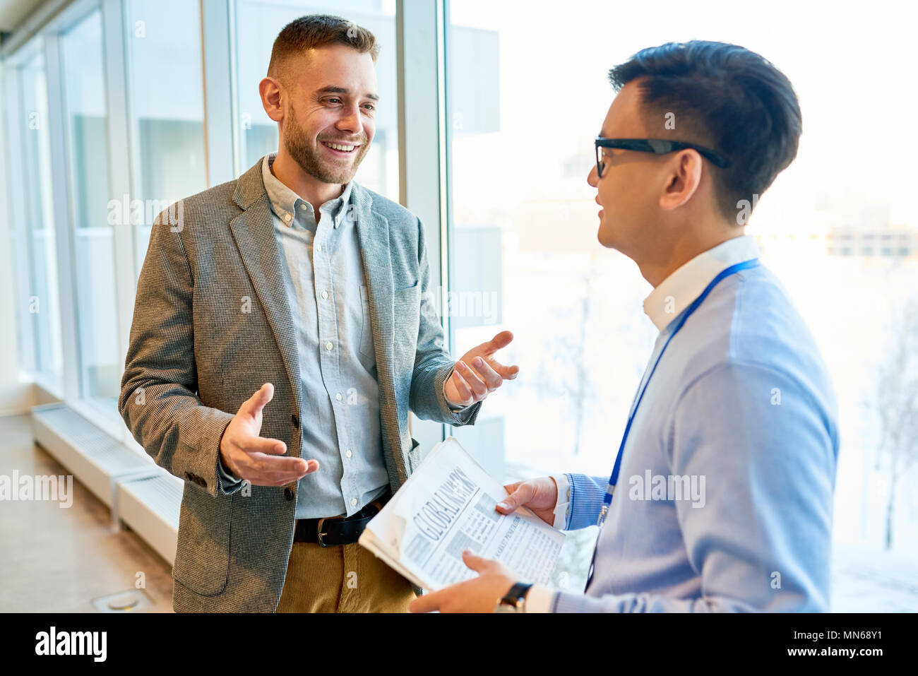 De taille moderne réussie businessman talking to Asian collègue souriant et heureux Banque D'Images