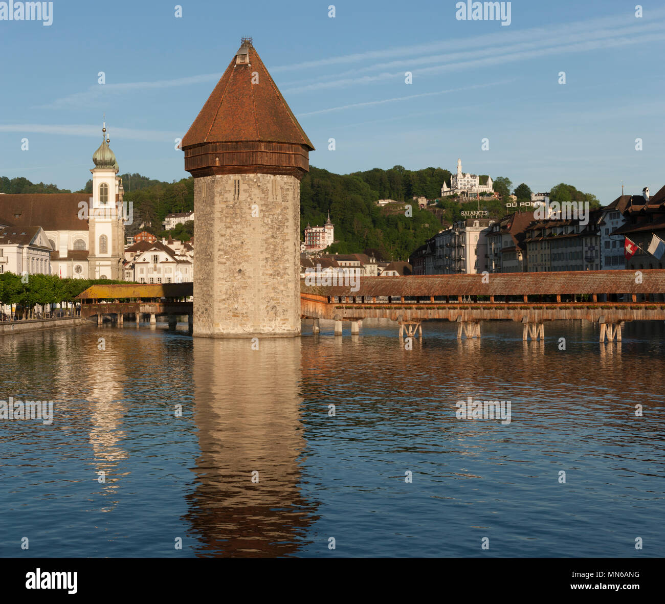Pont couvert historique et tour sur le lac de Lucerne en Suisse domaine du tourisme, des réflexions dans le lac, l'hôtel Gutsch, fond de ciel bleu Banque D'Images