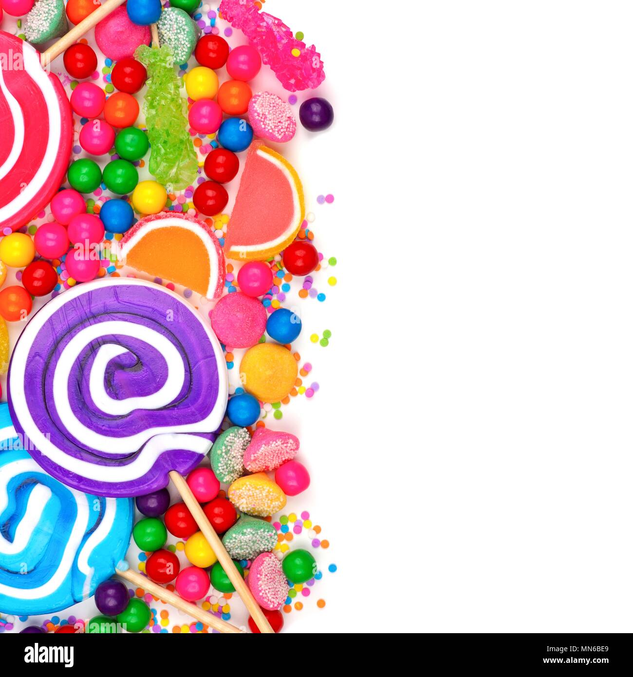 La frontière du côté d'un assortiment de bonbons colorés sur un fond blanc. Banque D'Images