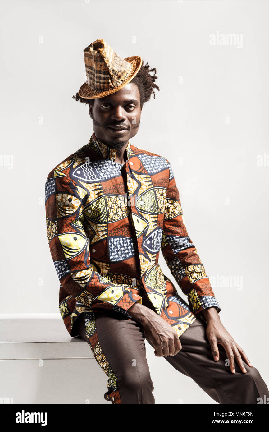 Bonheur fashion african man looking at camera et s'asseoir. Piscine, isolé sur fond gris Banque D'Images
