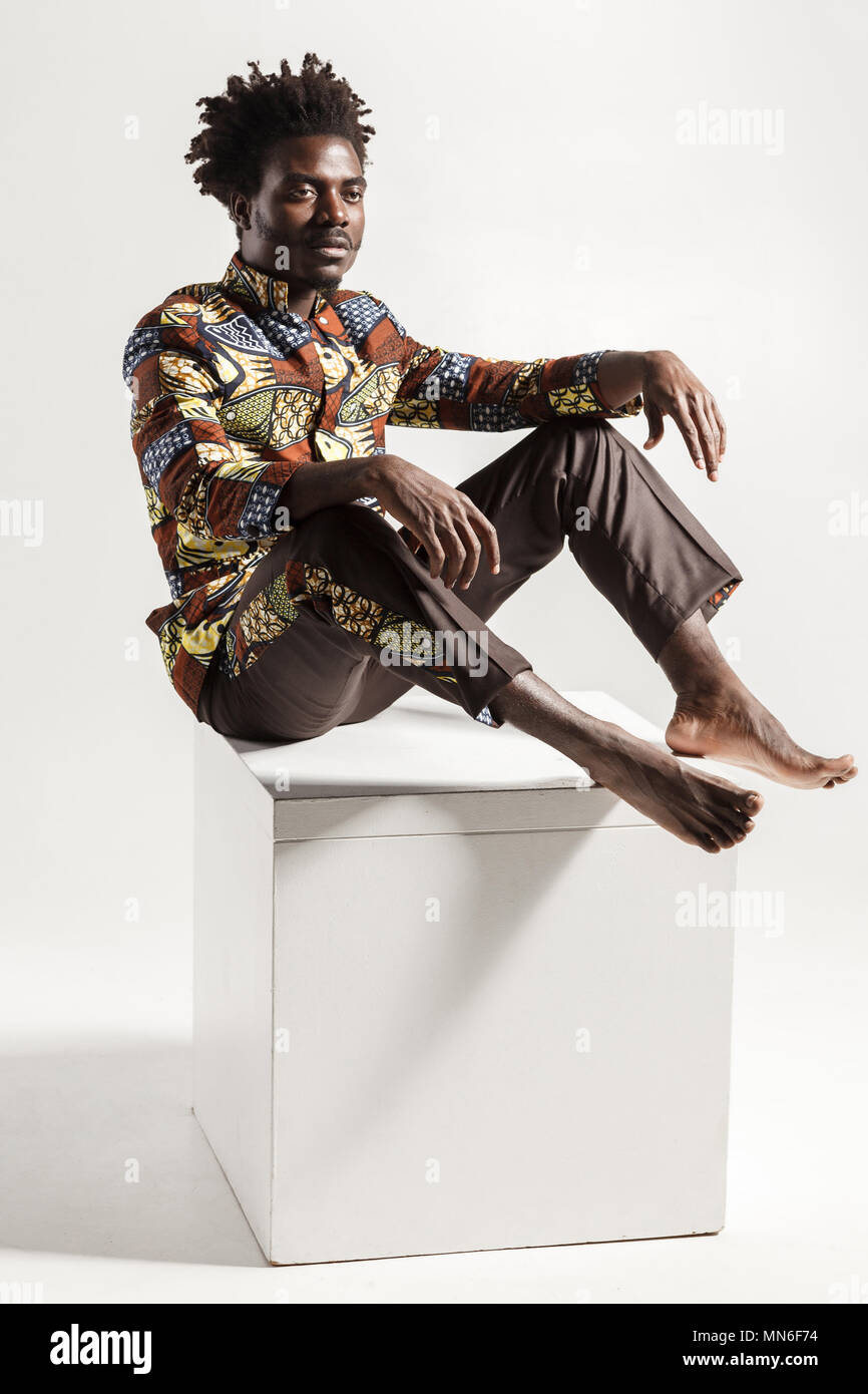 Célèbre et la mode african man posing on coub. Piscine, isolé sur fond gris Banque D'Images