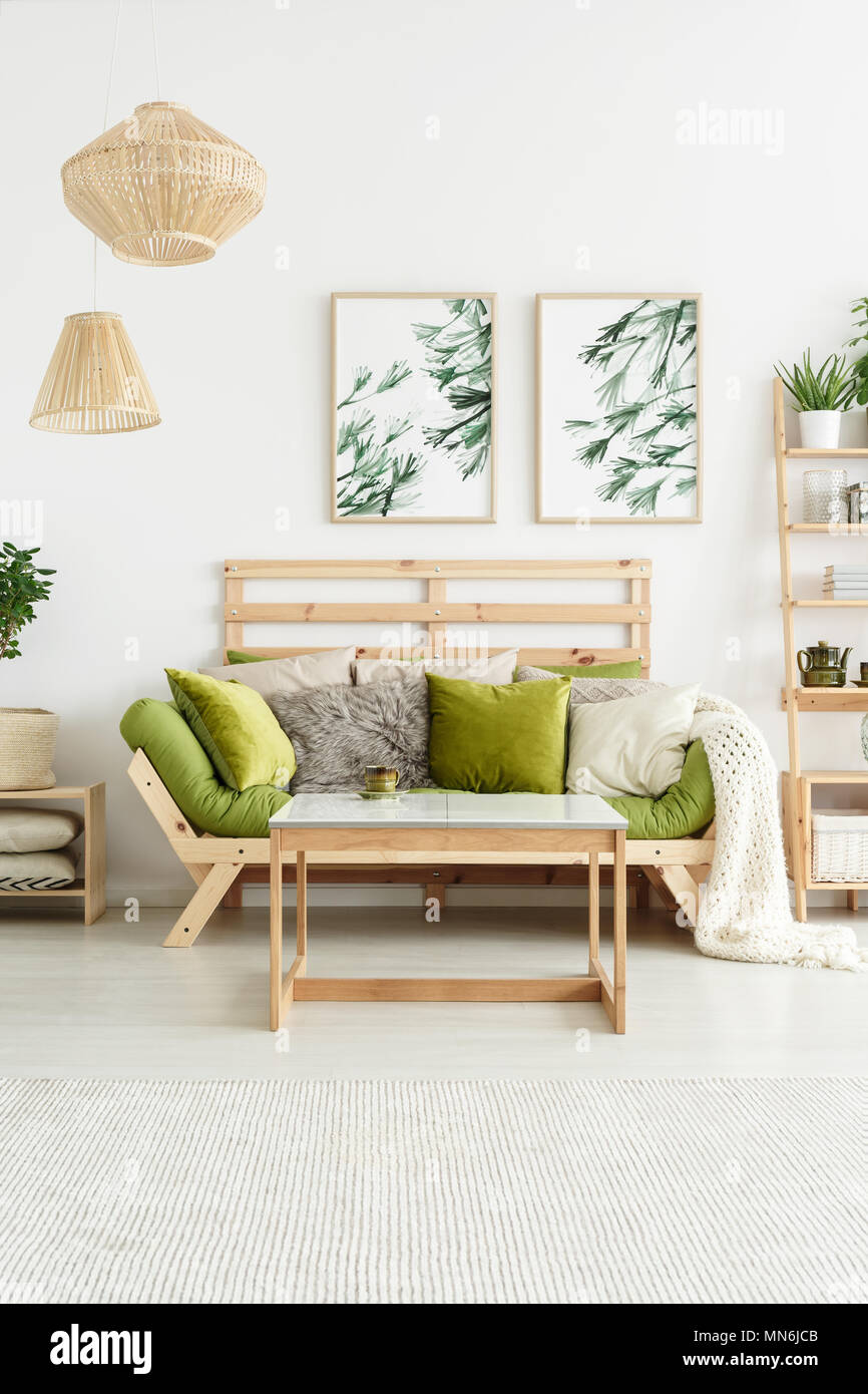 Des affiches avec des plantes accroché sur mur blanc dans l'élégant salon intérieur avec salon et table en bois vert Banque D'Images