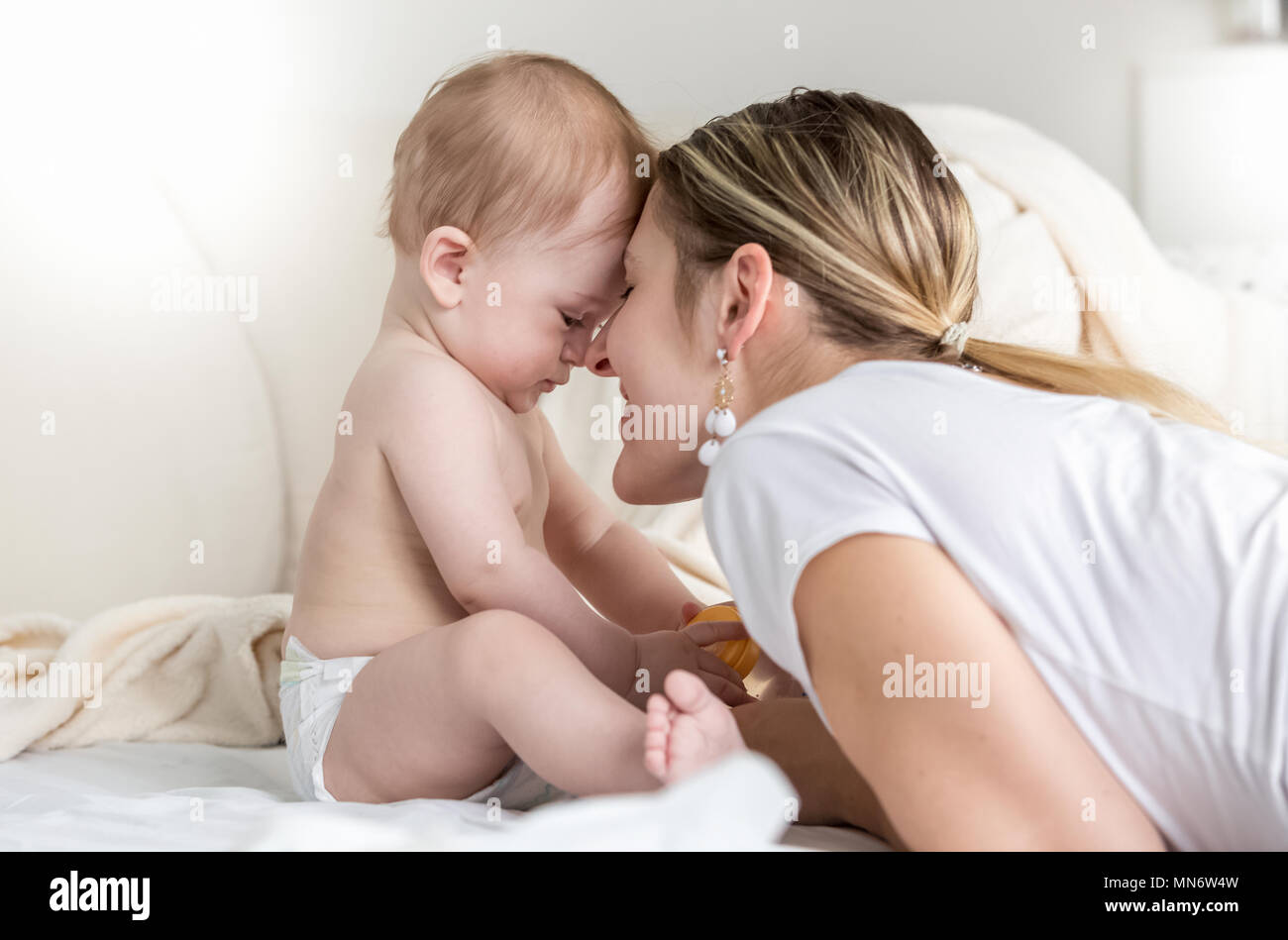 Portrait de belle jeune femme aimer son bébé en le regardant Banque D'Images