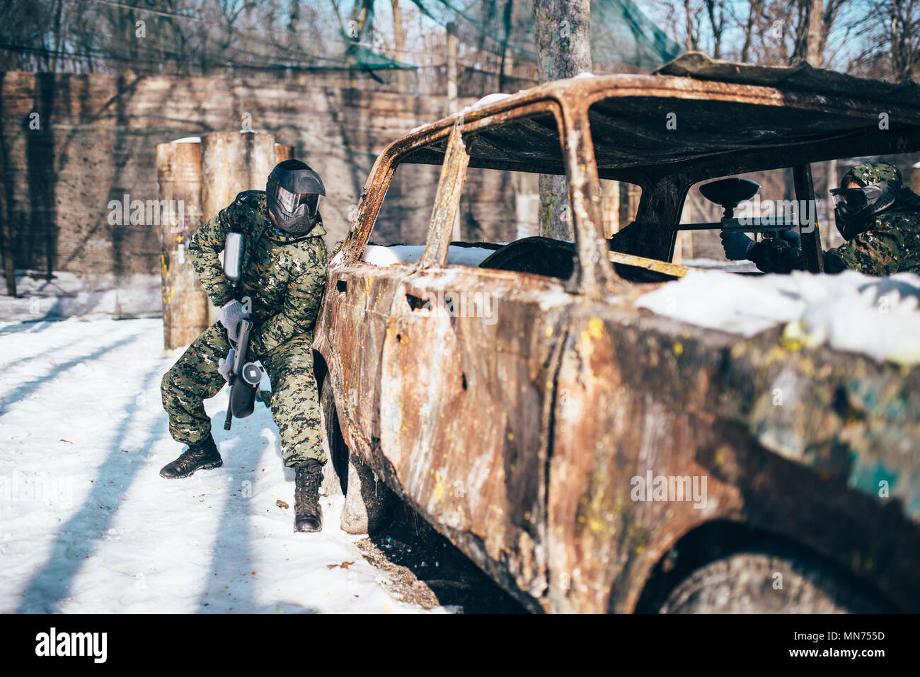 Paintball bataille autour de la forêt d'hiver en voiture brûlée, paintball. Sport extrême, jeu militaire Banque D'Images