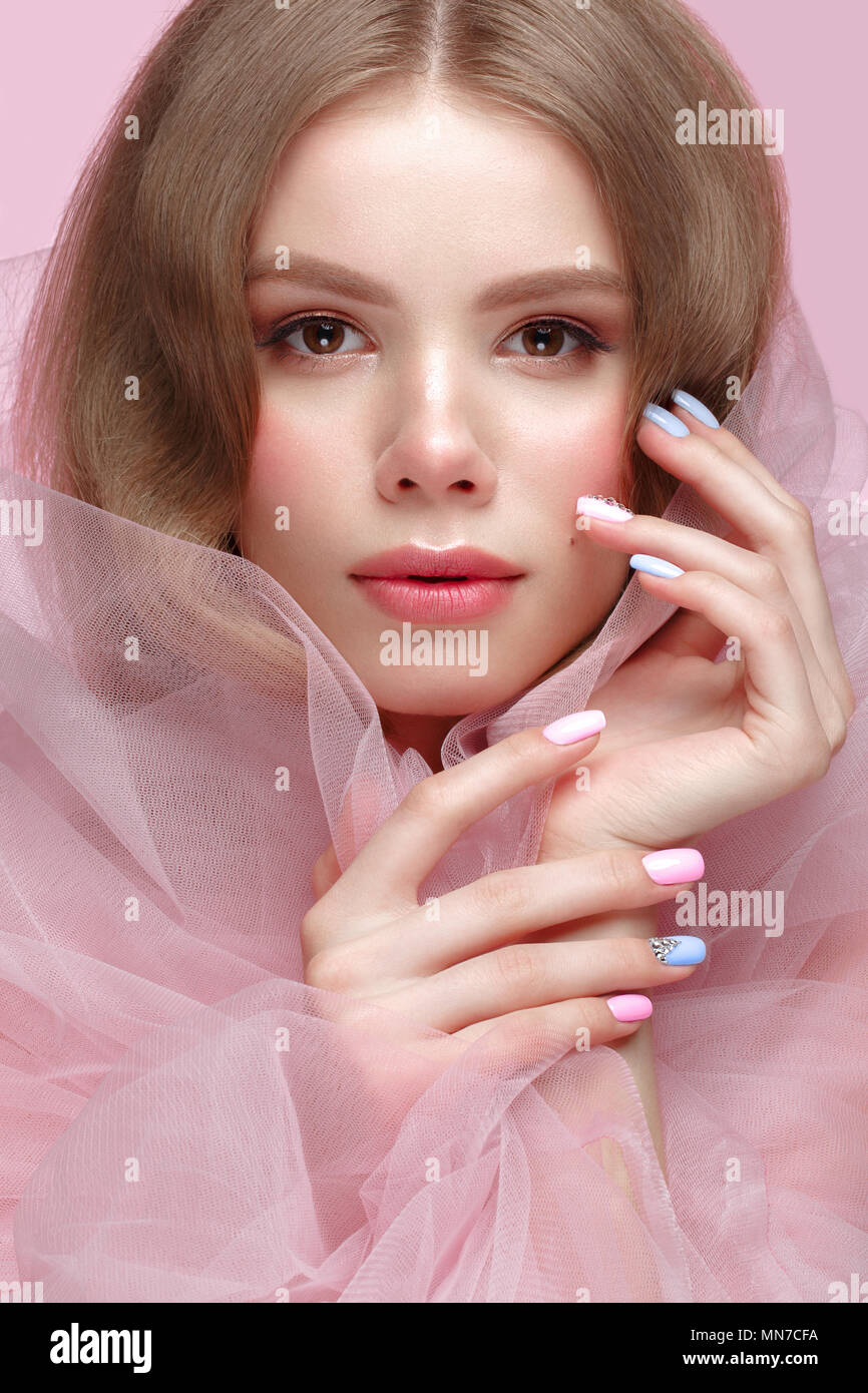 Belle fille avec la lumière douce et de maquillage manucure en vêtements rose. Beauté Visage. Ongles Design. Banque D'Images