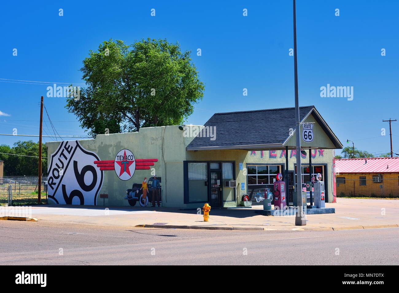 Tucumcari, New Mexico - Juillet 21, 2017 : Texaco gas station à Tucumcari, montrant une vieille Chrysler, la Texaco logo, un signe de route 66, une femme, et d'un cowb Banque D'Images