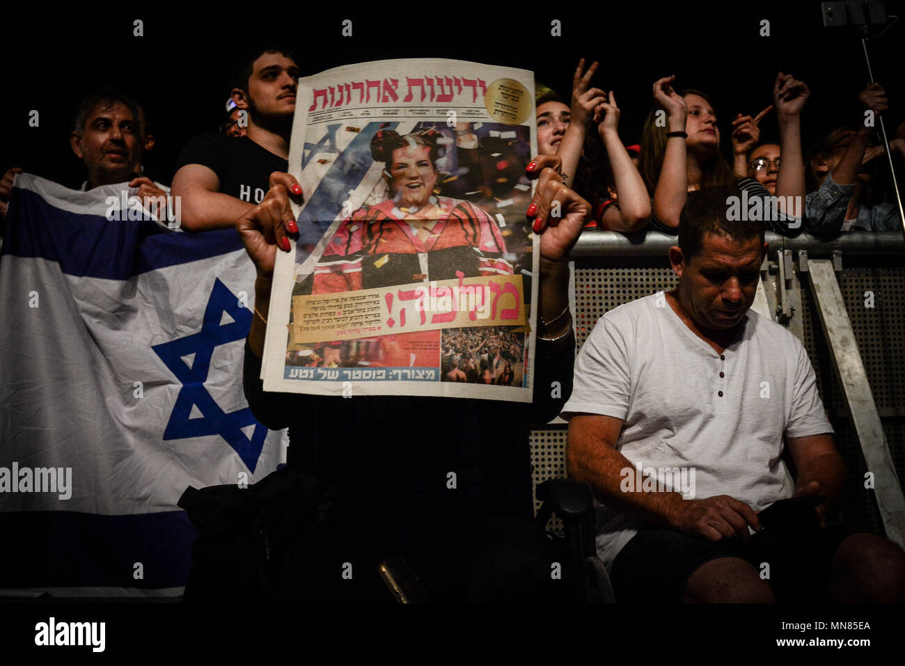 Tel Aviv, Israël. 14 mai, 2018. Un Israélien handicapé maintenant la première page d'un journal célébrant la victoire de singer Netta Barzilai, lauréat du 63e Concours Eurovision de la chanson. Une étape dans la place principale de Tel Aviv a été érigé le lundi en l'honneur de cette victoire historique. Des milliers de personnes, dont de nombreux enfants et jeunes, paniers la place. Certains portaient leurs cheveux dans le style de la marque Barzilai, l'hôtel de ville était illuminé en son honneur avec le mot "jouet", titre de la chanson à succès. Crédit : Laura Chiesa/Pacific Press/Alamy Live News Banque D'Images