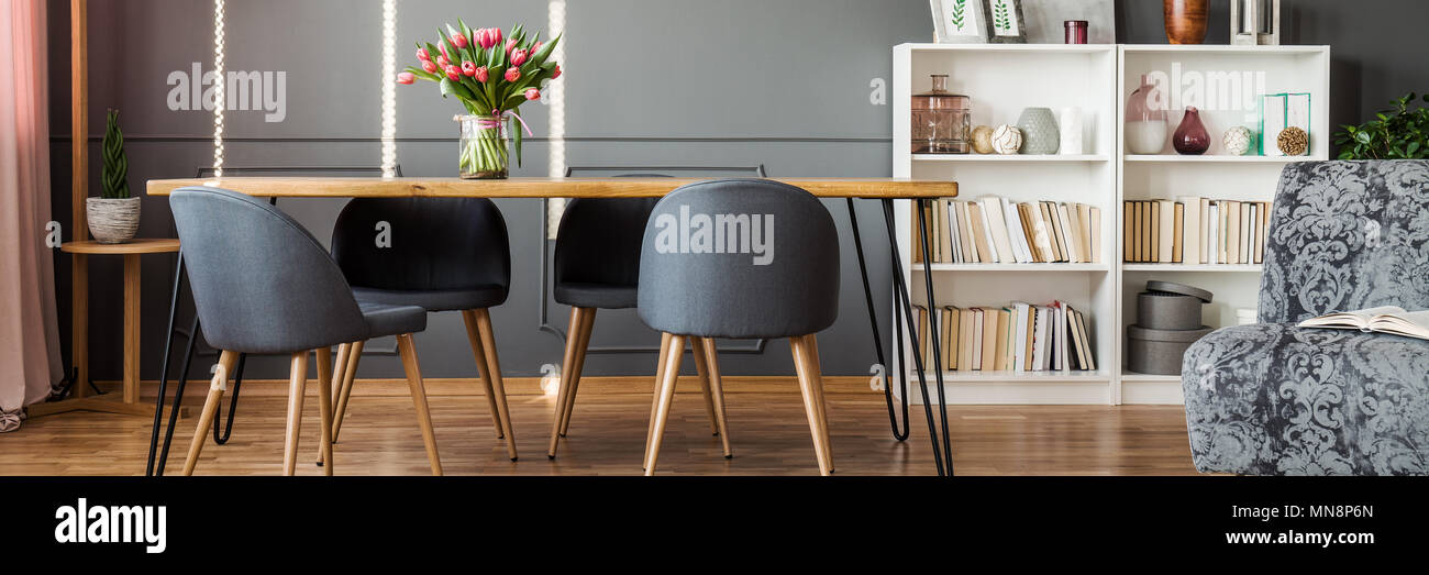 Quatre chaises gris debout par une épingle à l'intérieur de la table de salle à manger avec coin lecture Banque D'Images