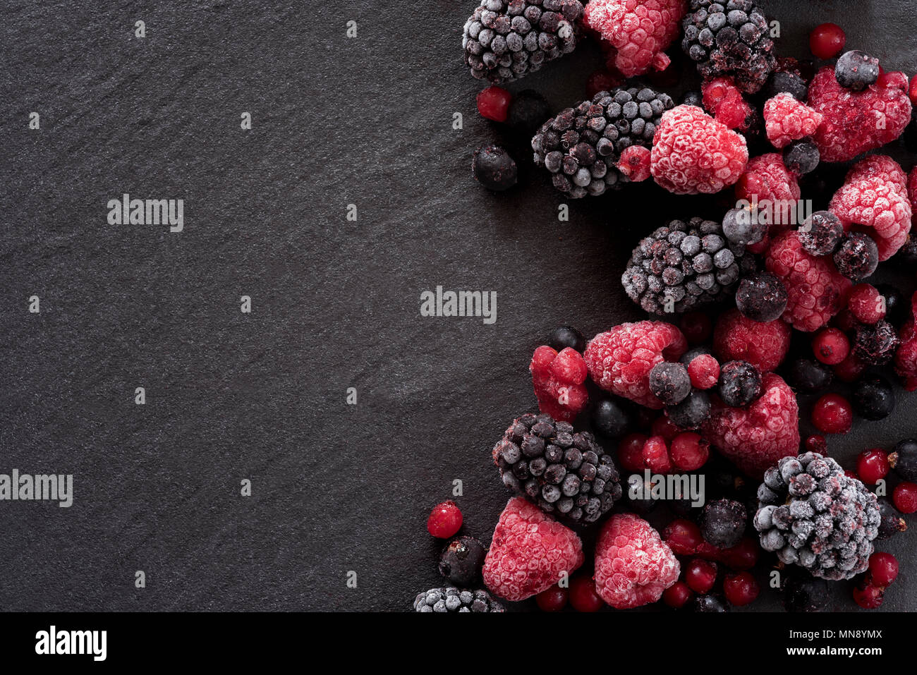 Les baies d'été gelés sur un arrière-plan en ardoise, blackberry, framboises et groseilles. Banque D'Images