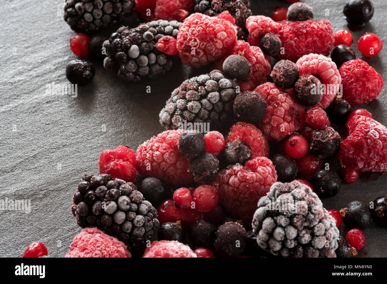 Les baies d'été gelés sur un arrière-plan en ardoise, blackberry, framboises et groseilles. Banque D'Images