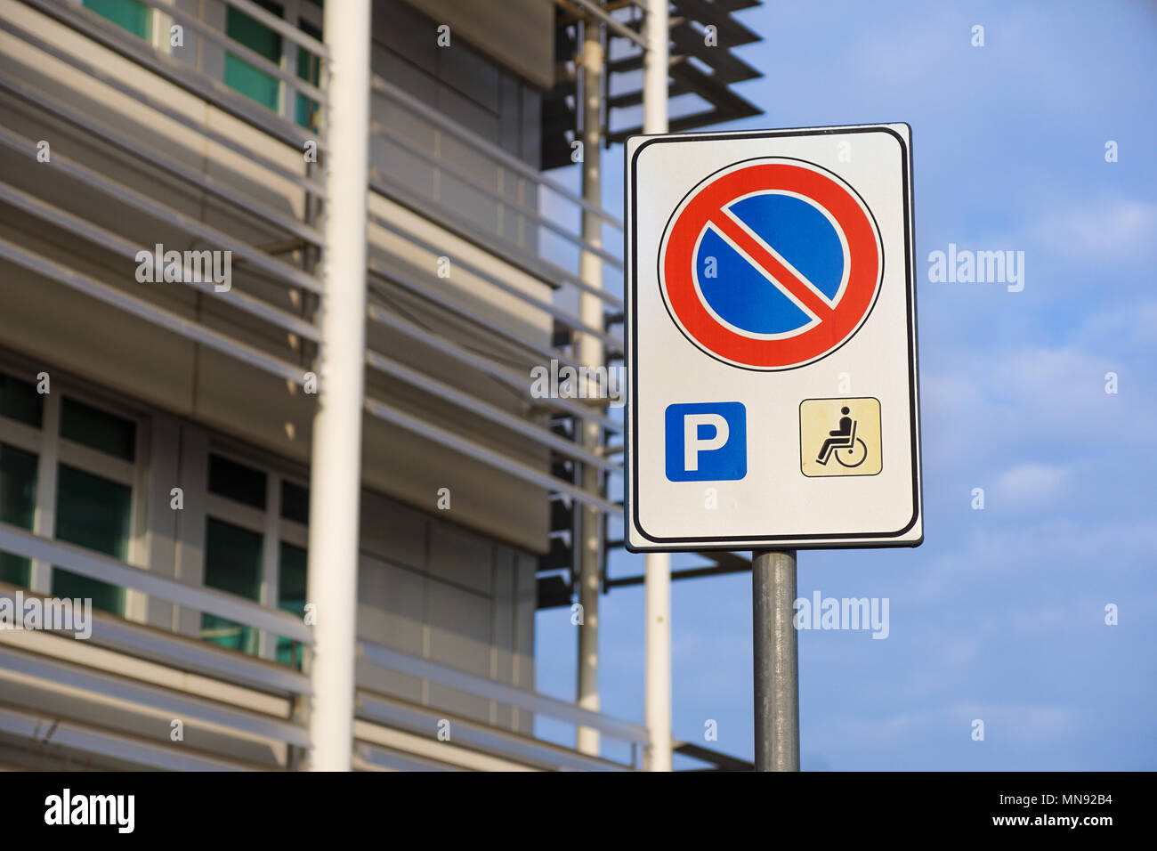 Marque signe handicapés place de stationnement, permis de stationnement handicapés signe sur poteau avec dépanneur dans la zone de la station de gaz à fond, copy space Banque D'Images