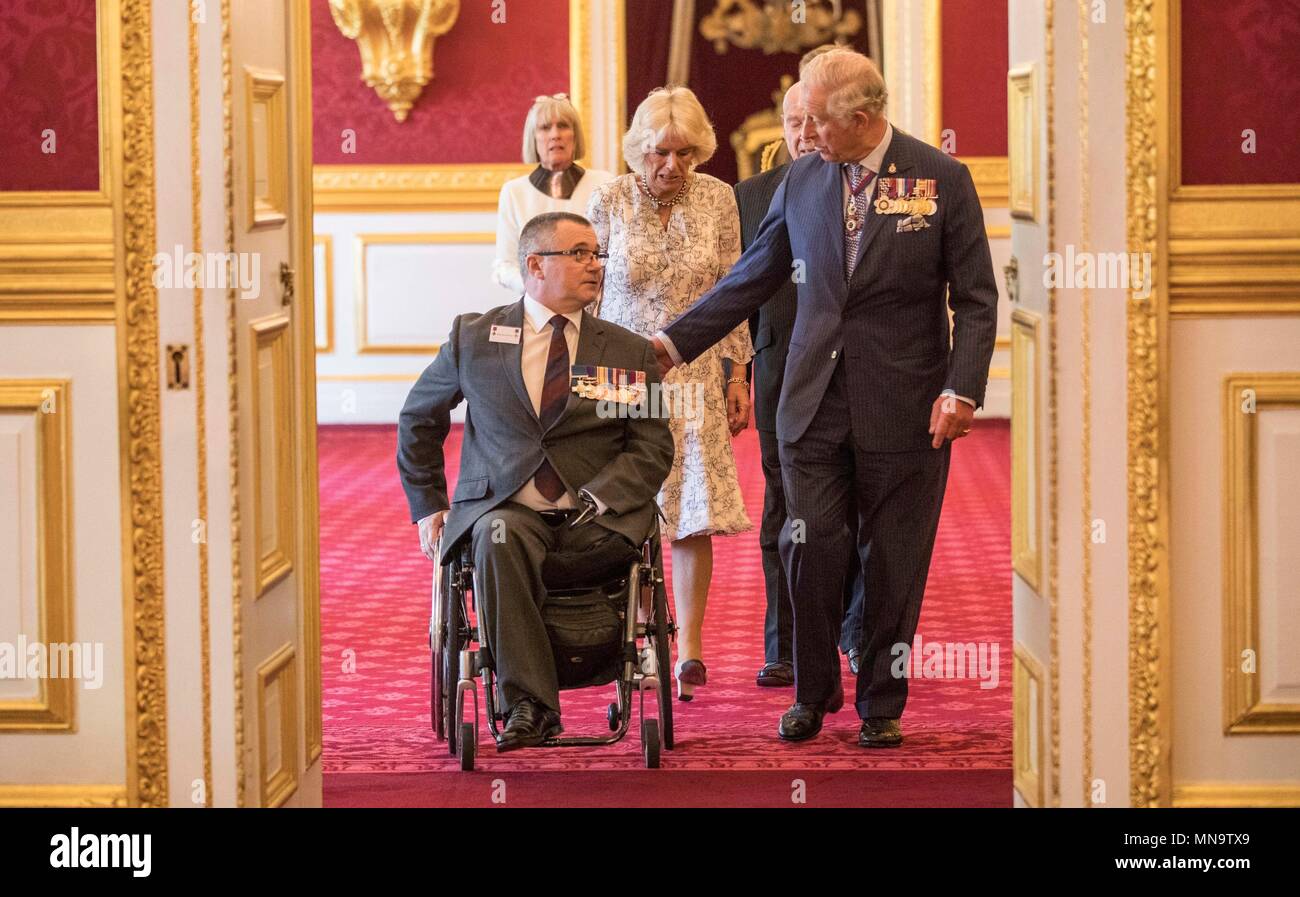 Le Major Peter Norton GC, qui a perdu un bras et une jambe tout en dirigeant une équipe de neutralisation en Iraq en 2005, avec le Prince de Galles et la duchesse de Cornouailles lors d'un tea party à Clarence House de Londres pour les membres de la Croix de Victoria et George Cross Association. Banque D'Images