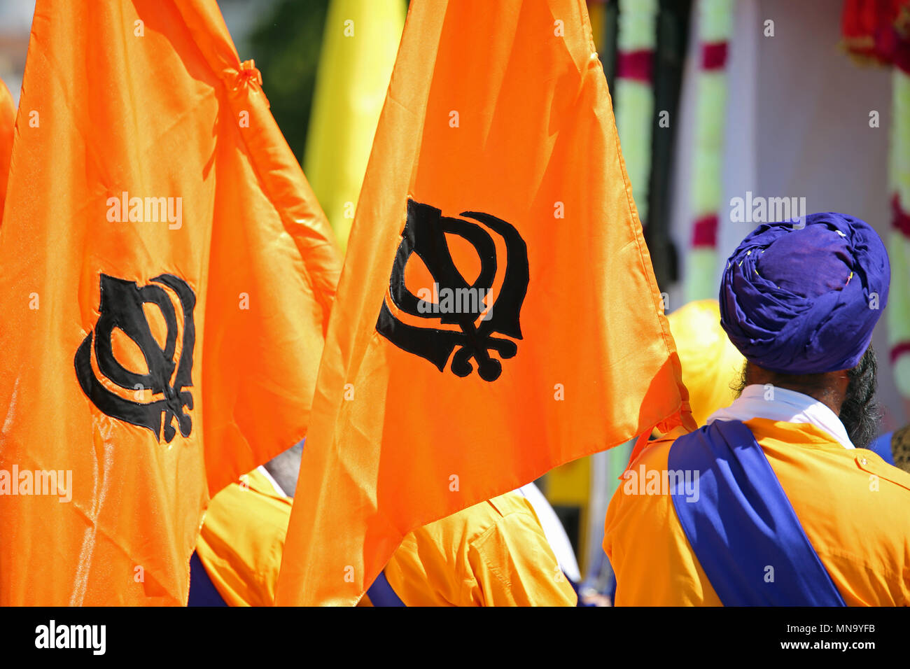Drapeaux orange avec le sikhisme appelé symbole Khanda et un homme à turban bleu Banque D'Images