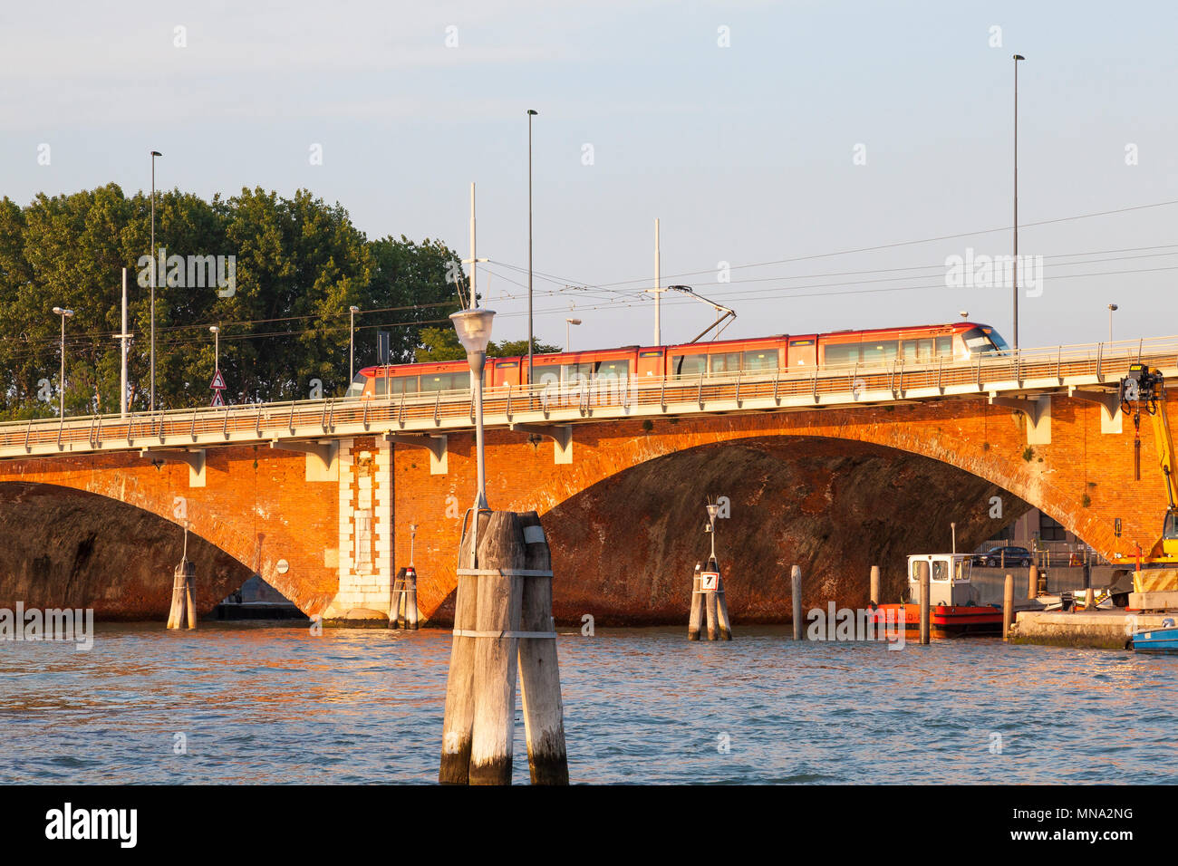 Le tramway traversant le Ponte della Libertà reliant Venise et Mestre centre historique sur la lagune de Venise au coucher du soleil, Venise, Vénétie, Italie. Transp Banque D'Images