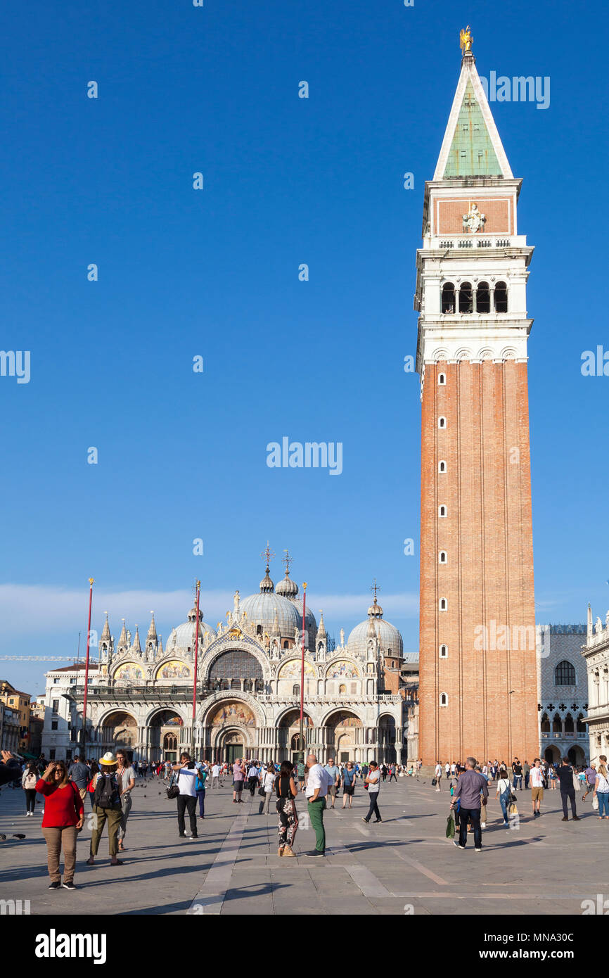 Piazza San Marco, La Basilique de San Marco et le Campanile au coucher du soleil, Venise, Vénétie, Italie. La Place St Marc, La Cathédrale de St Marc. Les touristes éparpillés en fo Banque D'Images