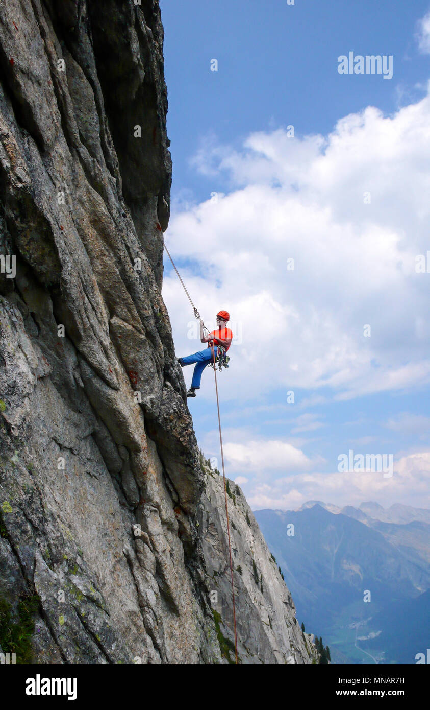 Rock climber vêtus de couleurs vives sur un granit raide route escalade dans les Alpes Banque D'Images