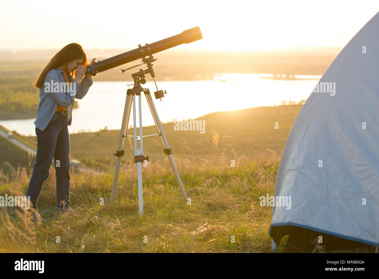 Jeune femme à la vue par le télescope sur la colline du su Banque D'Images
