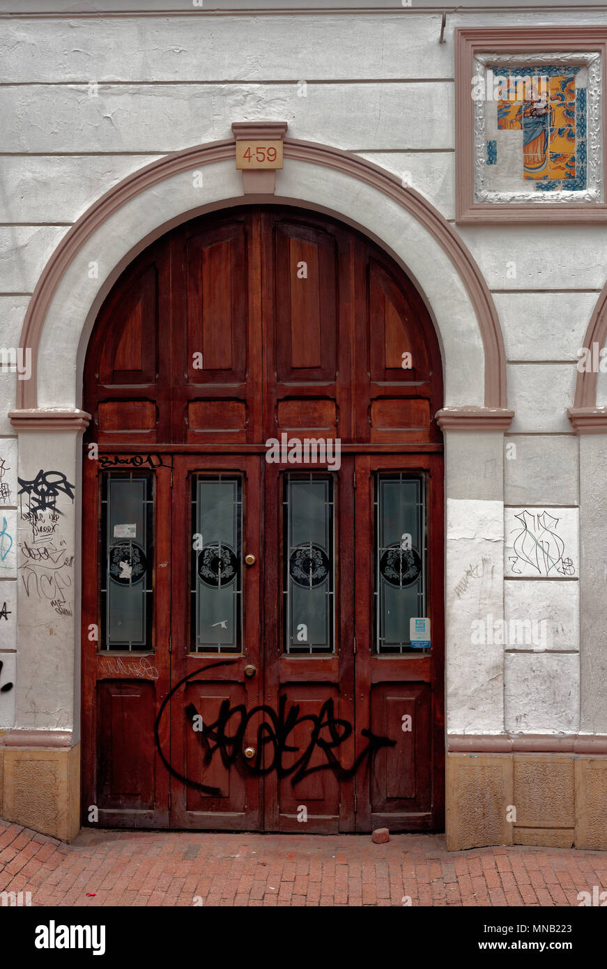 Porte en bois avec un arc et une mosaïque de la Vierge, rue de Bogota, Colombie Banque D'Images