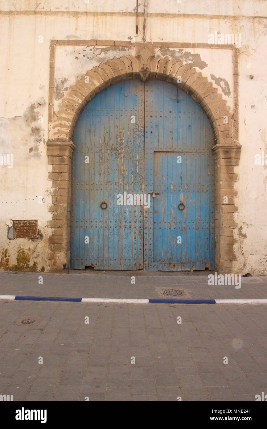 Une vieille porte bleue qui a c'est la décoloration et décollait à Essaouira, Maroc Banque D'Images