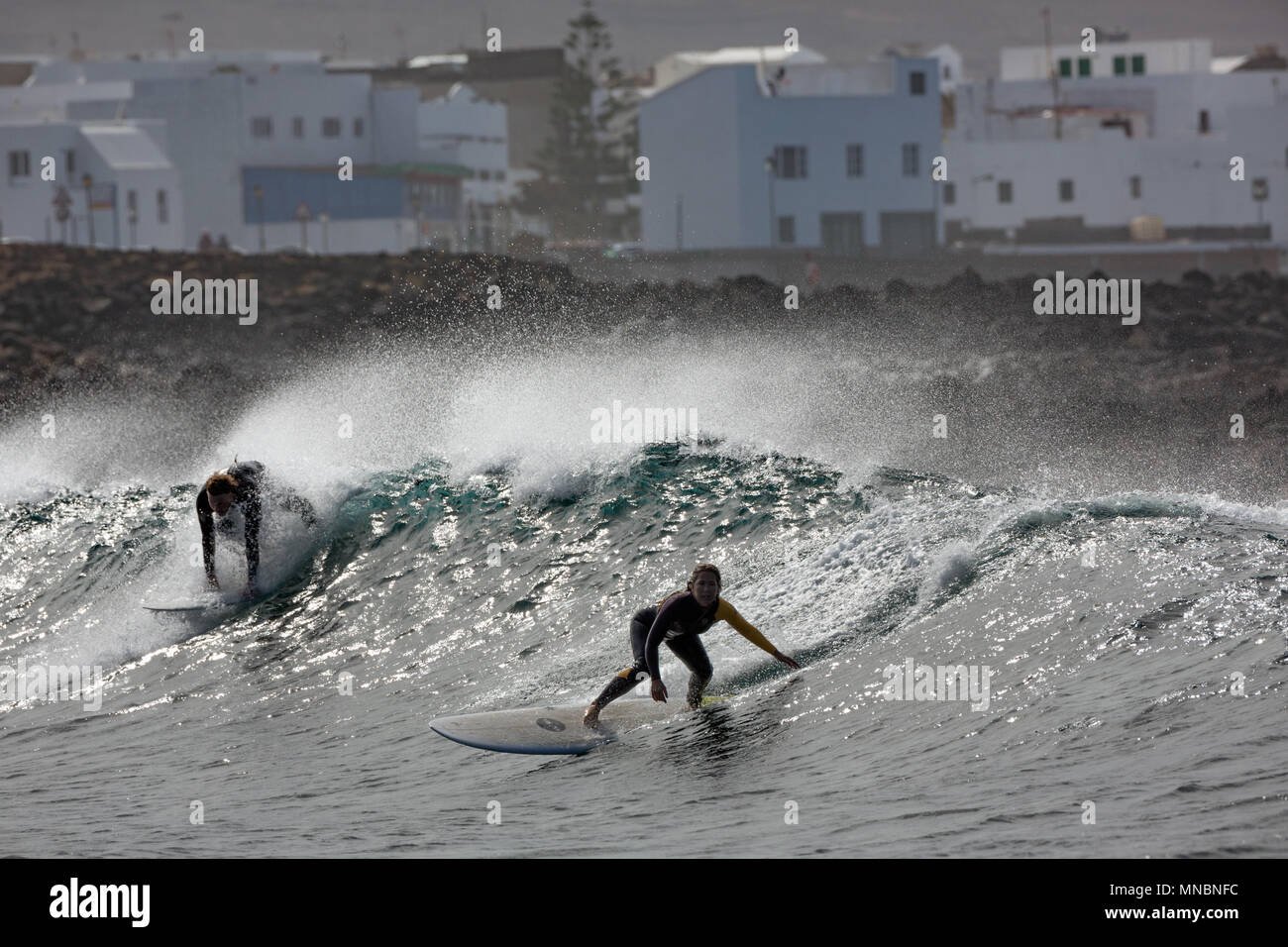 LANZAROTE, îles Canaries, Espagne : attraper les surfeurs vagues devant le village La Santa. Banque D'Images