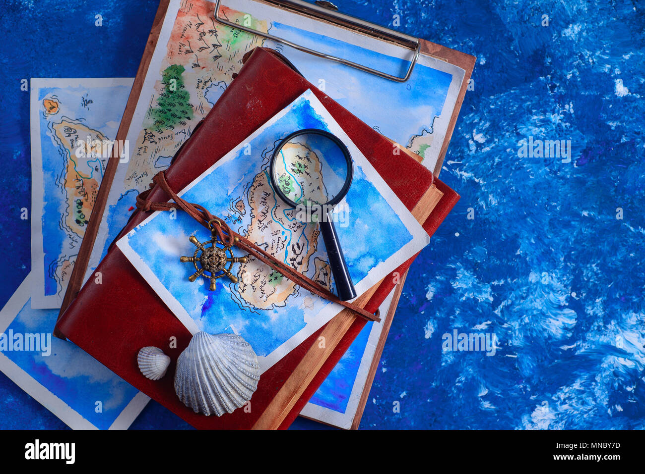 Voyages en mer et la peinture concept. Carte fantaisie aquarelle sur cuir couvrir le capitaine revues avec une loupe sur un fond bleu marine avec l'exemplaire Banque D'Images