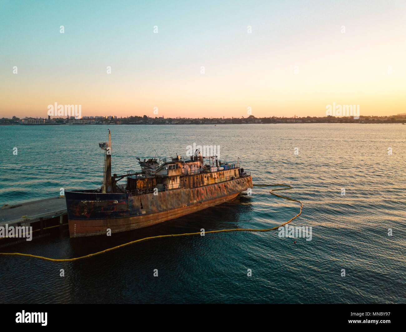 Vieux bateau rouillé abandonné pendant le coucher du soleil Banque D'Images