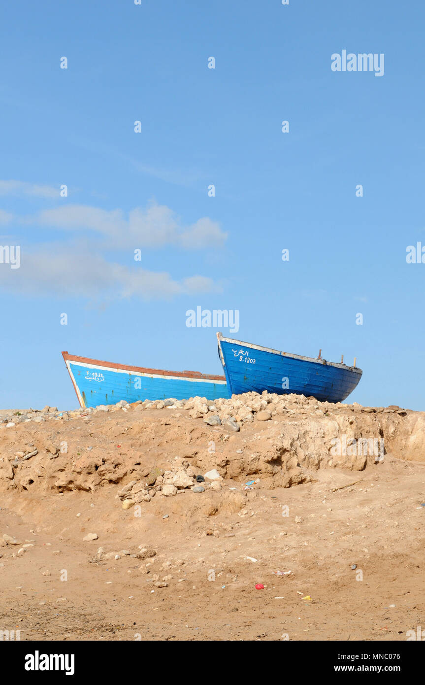 Bateaux de pêche marocaines tiré vers le haut sur la plage et juste à l'extérieur des cabanes de pêche Tagazoute Maroc Banque D'Images