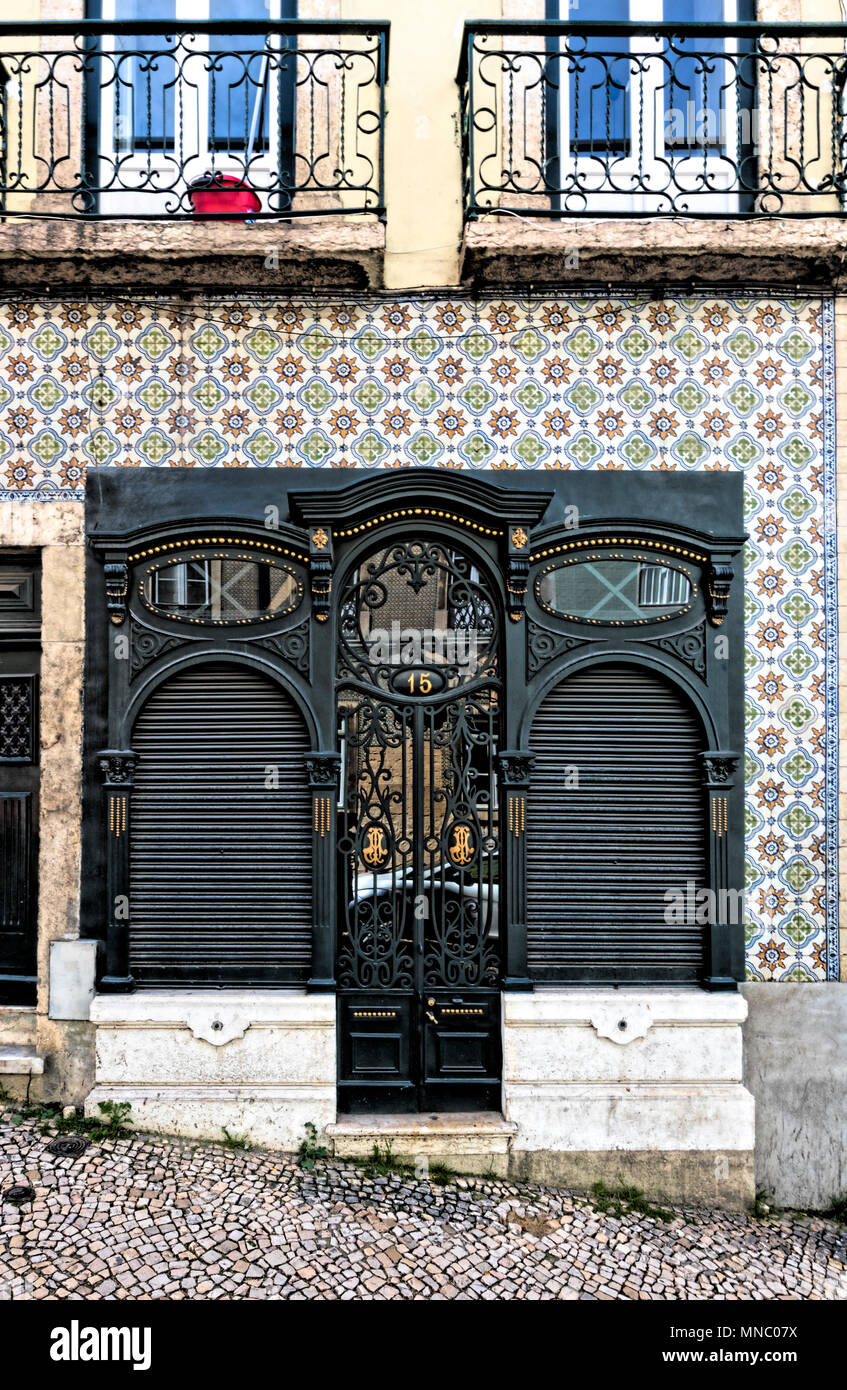 Façade de maison de ville à la place Martim Moniz avec porte noire avec décoration d'or, entouré de mur carrelé en céramique Banque D'Images