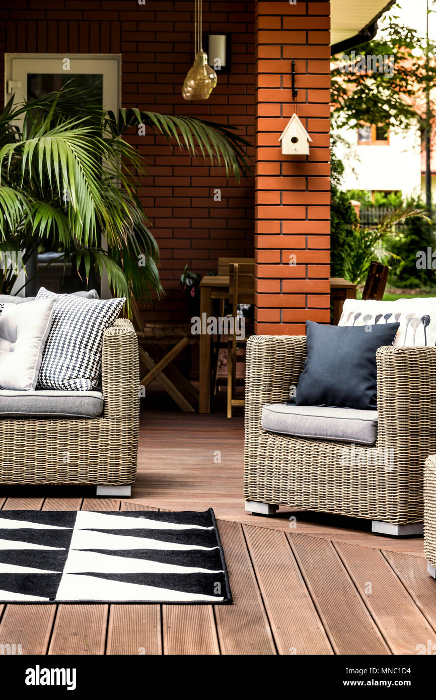 Terrasse en bois d'une maison d'été avec fauteuils et canapés en rotin confortables Banque D'Images