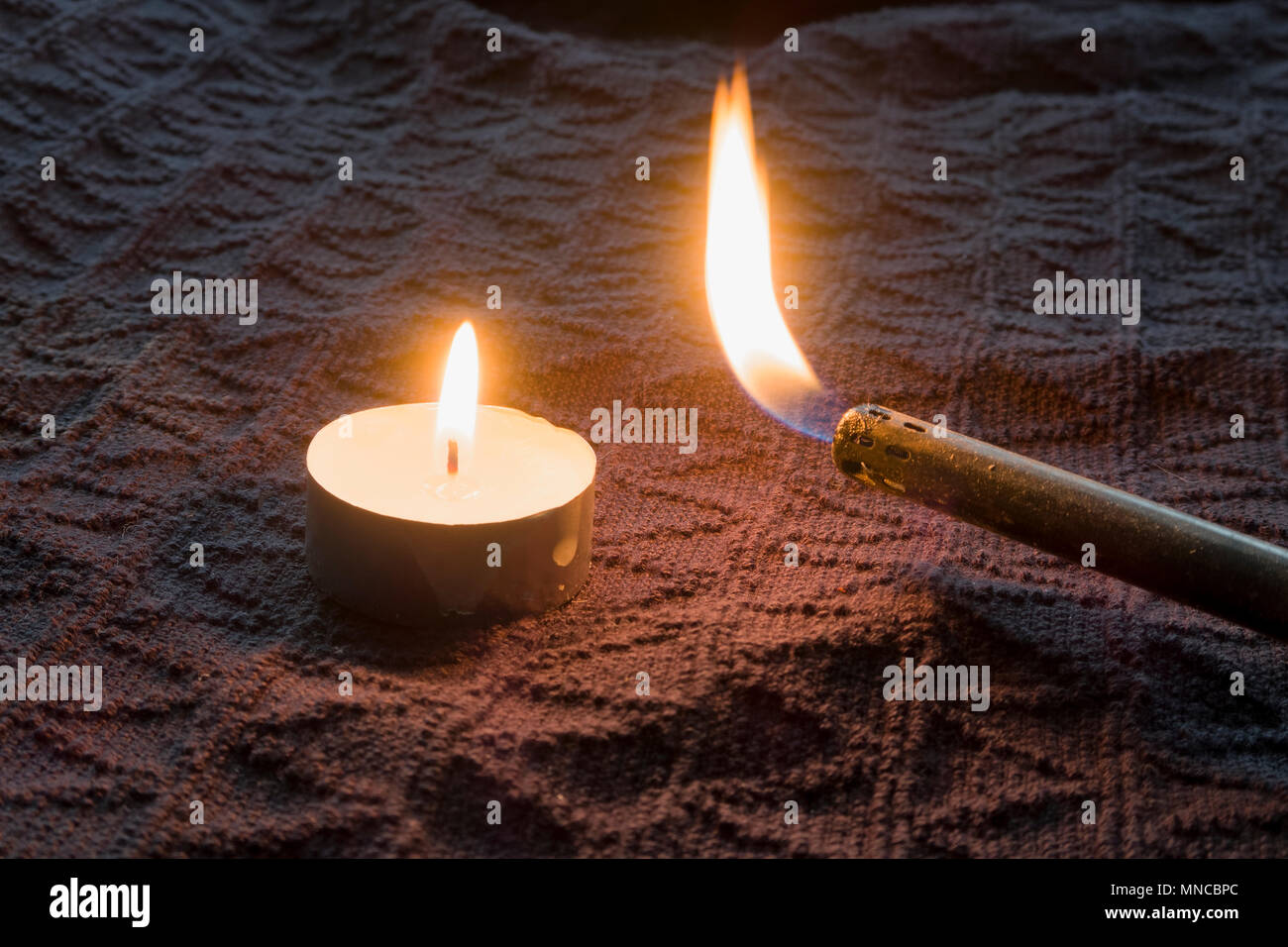 Briquet à gaz l'éclairage d'une bougie. Les bougies peuvent être romantique  ou ils peuvent être tout à fait nécessaire pour l'éclairage Photo Stock -  Alamy