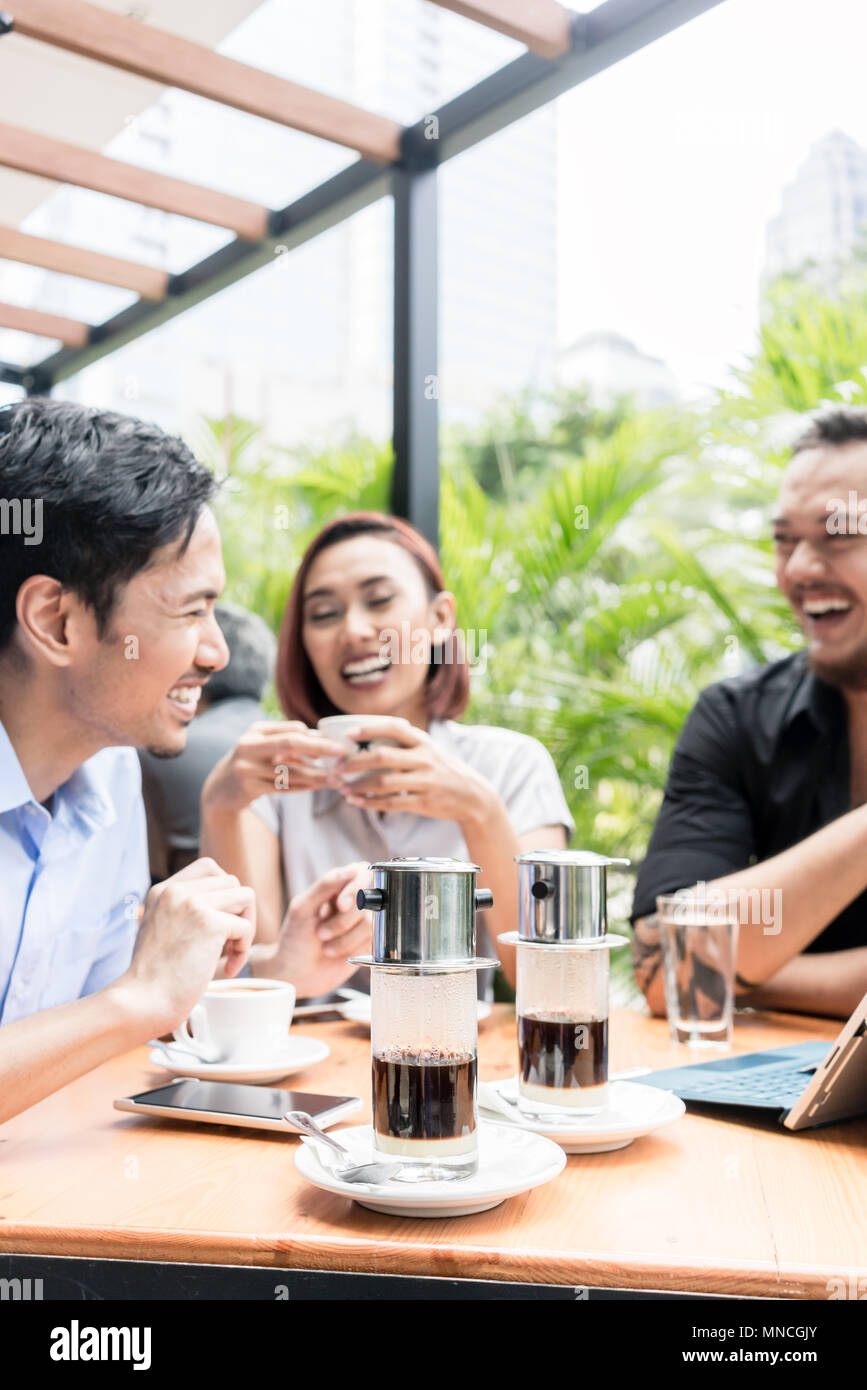 Café vietnamien servi sur la table des trois amis à l'extérieur Banque D'Images