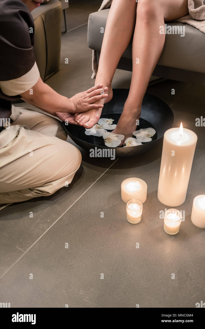 Mains d'un thérapeute d'Asie au cours de traitement le lavement des pieds Banque D'Images