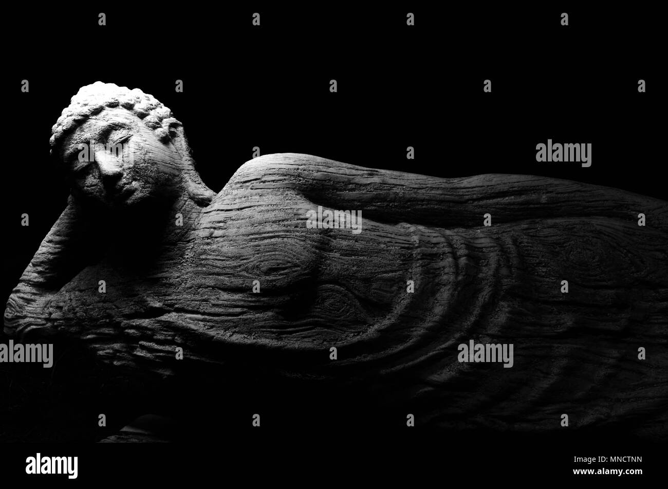 Bouddha couché Fond noir Lumière douce Banque D'Images