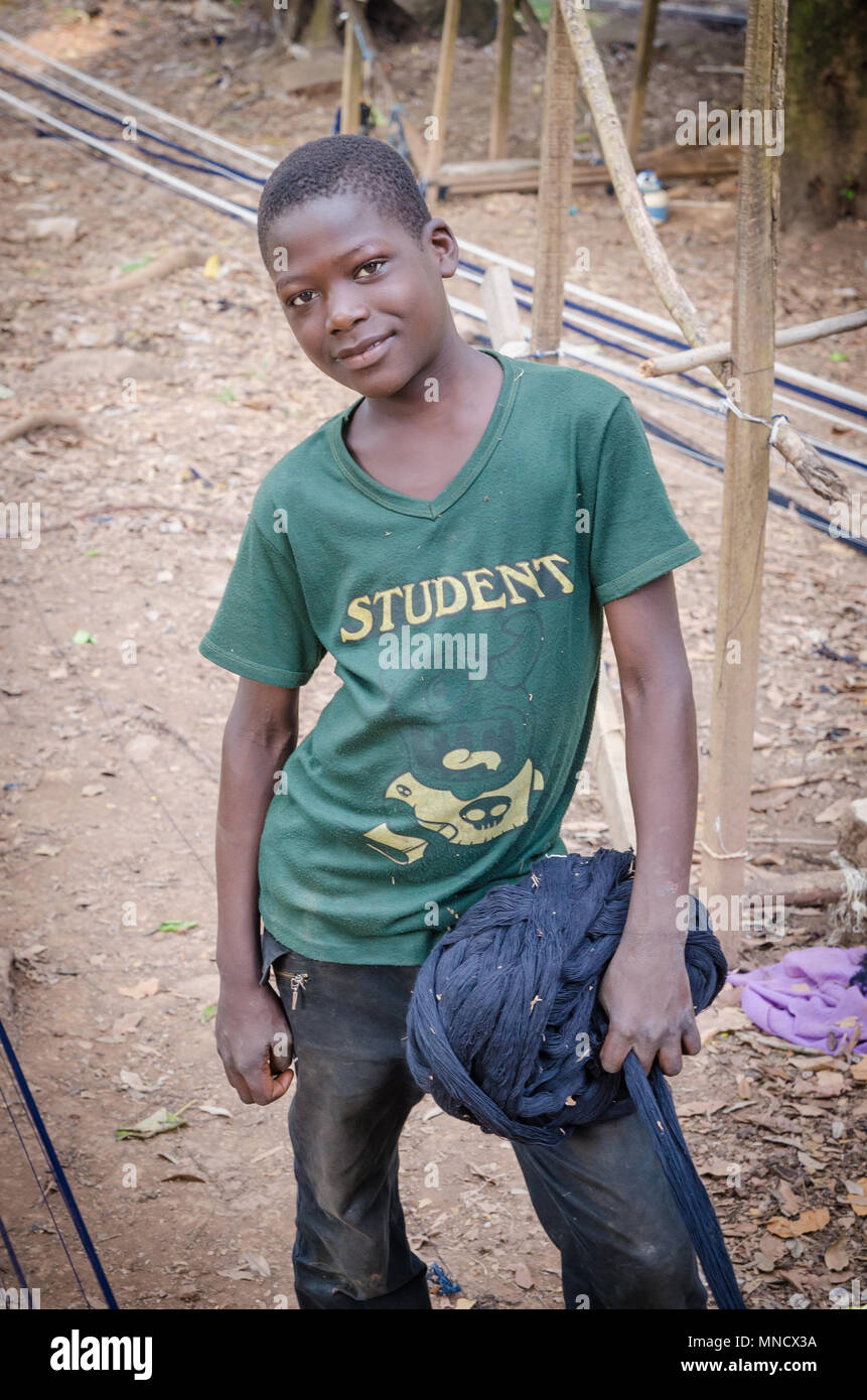L'homme, Côte d'Ivoire - Janvier 31,2014 africain non identifié : weaver boy avec le rouleau de tissu à l'extérieur Banque D'Images