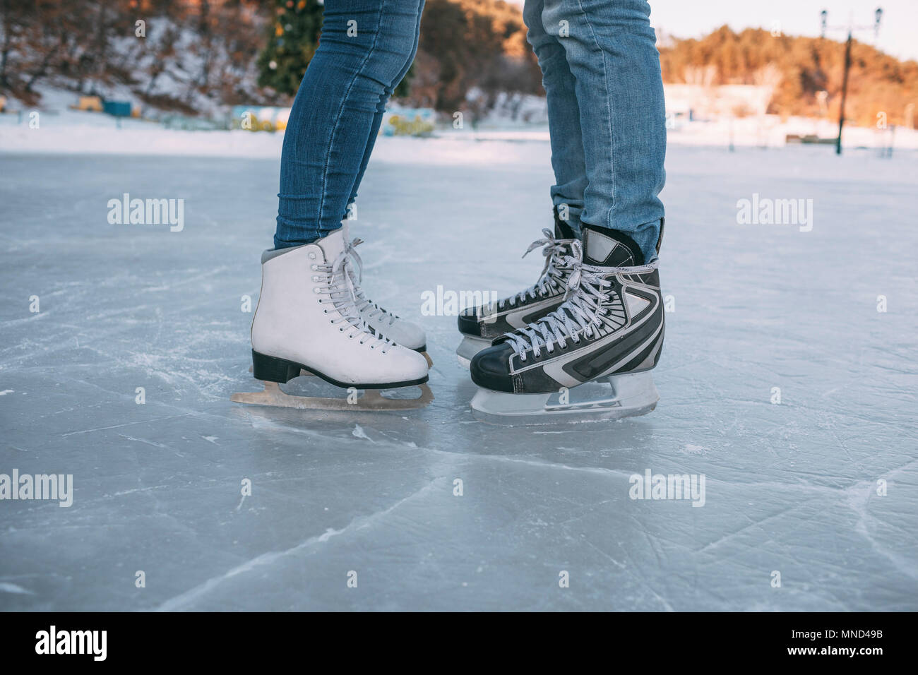 La section basse du couple portant des patins à glace sur la patinoire Banque D'Images