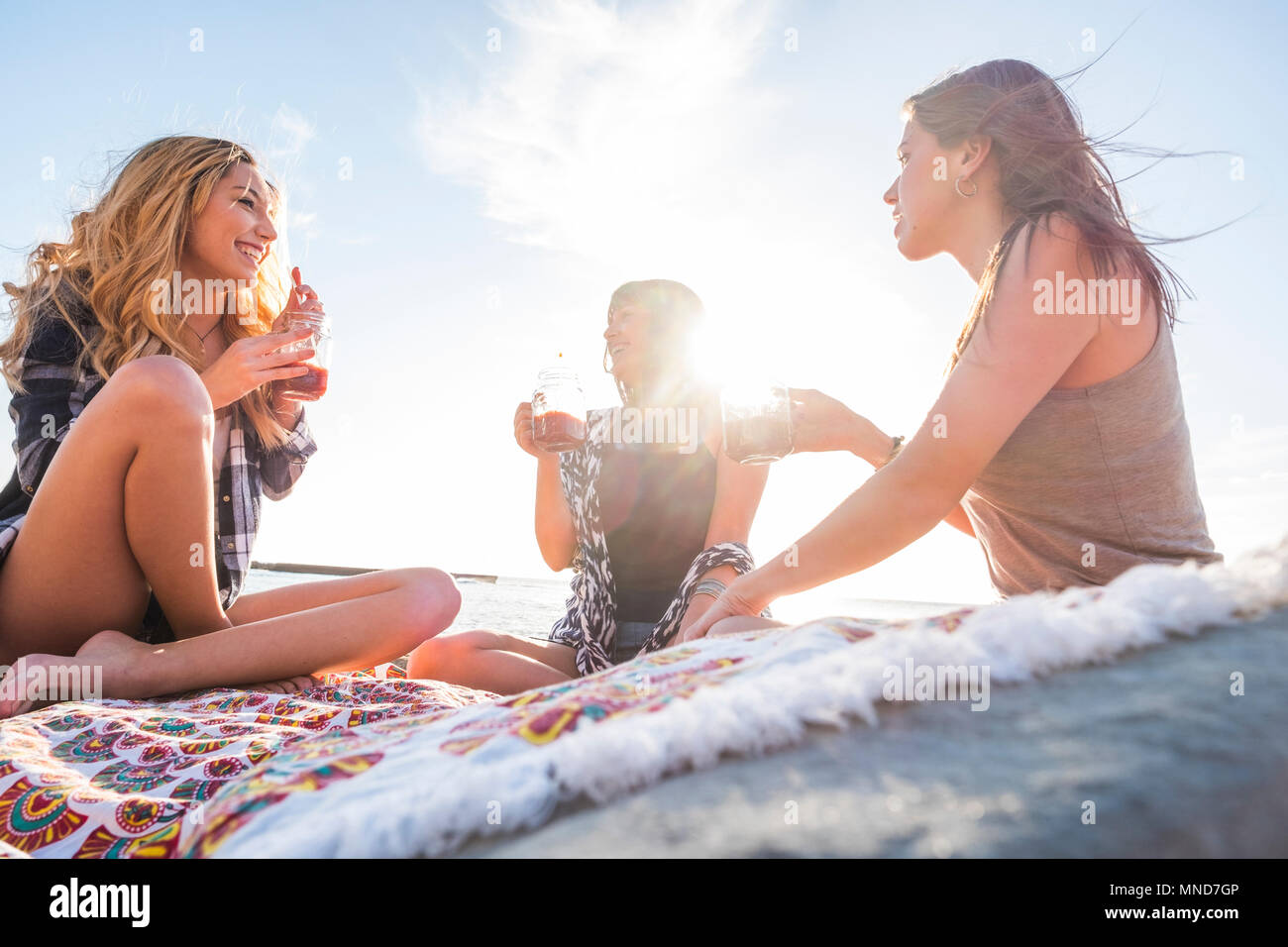 Groupe de jeunes femmes ami boire ensemble un jus de fruit sur un rock beach à Ténérife. Relation pour une équipe à l'ejoy locations et de bonheur. Banque D'Images
