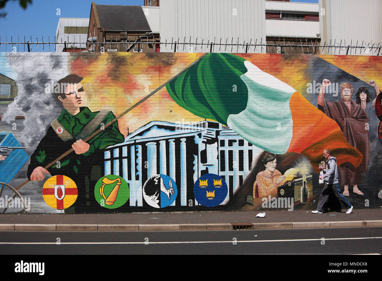 Un homme passe devant le mur de la paix sur la Falls Road, l'ouest de Belfast, mai 2018. La Falls Road (de l'Irlandais na túath bhFál, signifiant 'territoire de la mise en boîtier) est la route principale de l'ouest de Belfast, Irlande du Nord, allant de Divis Street dans le centre-ville de Belfast à Andersonstown dans les banlieues. Son nom est synonyme de la communauté républicaine dans la ville, tandis que la route est principalement Shankill voisins loyaliste, séparée de la Falls Road par lignes de paix. La route est généralement appelée la Falls Road, plutôt que comme Falls Road. Il est connu sous le nom de la Faas car de Ulste Banque D'Images