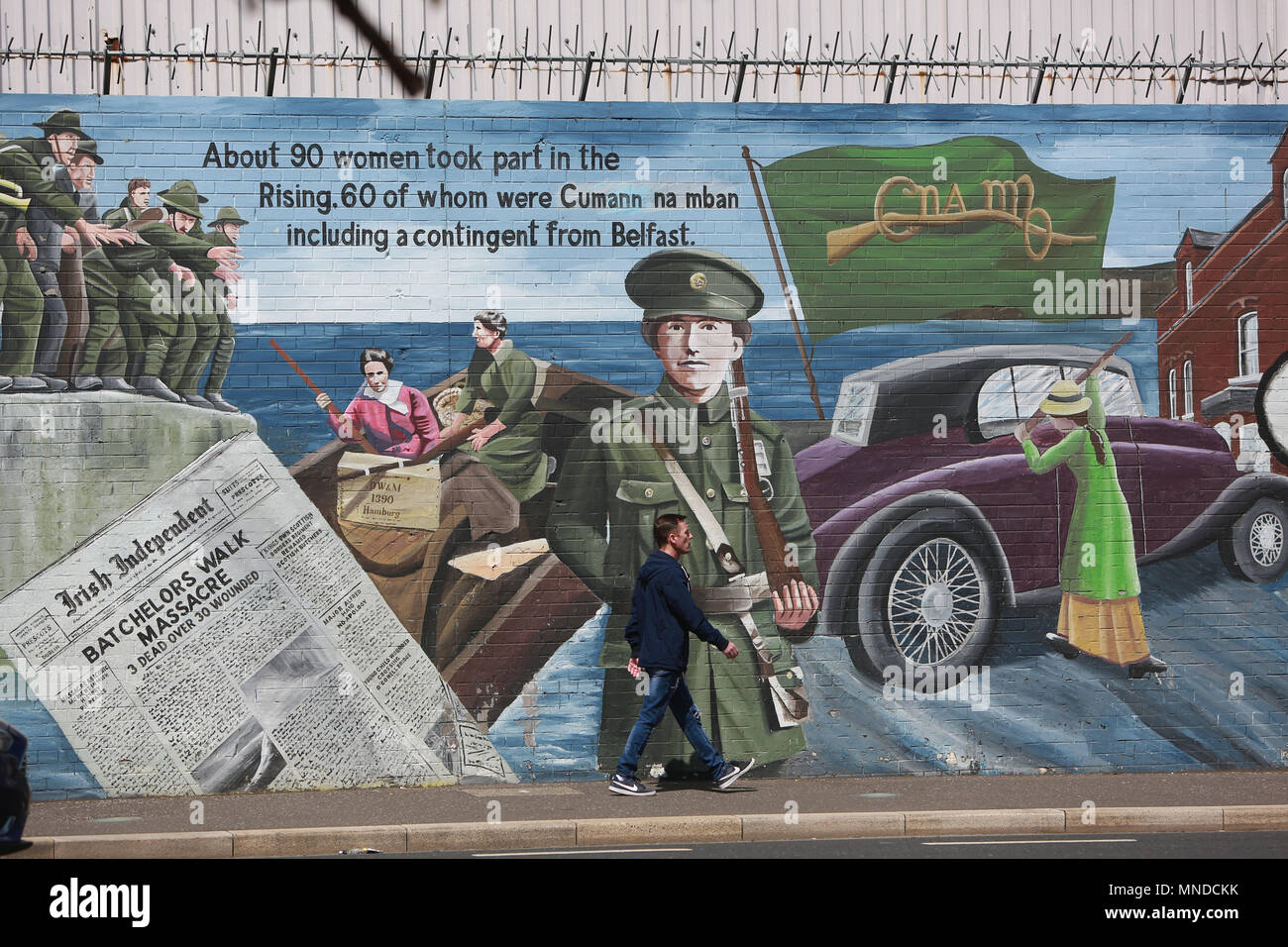 Un homme passe devant la zone la plus visitée par les touristes de la Falls Road, l'ouest de Belfast, mai 2018. La Falls Road (de l'Irlandais na túath bhFál, signifiant 'territoire de la mise en boîtier) est la route principale de l'ouest de Belfast, Irlande du Nord, allant de Divis Street dans le centre-ville de Belfast à Andersonstown dans les banlieues. Son nom est synonyme de la communauté républicaine dans la ville, tandis que la route est principalement Shankill voisins loyaliste, séparée de la Falls Road par lignes de paix. La route est généralement appelée la Falls Road, plutôt que comme Falls Road. Il est connu sous le nom de la Faas car de Banque D'Images