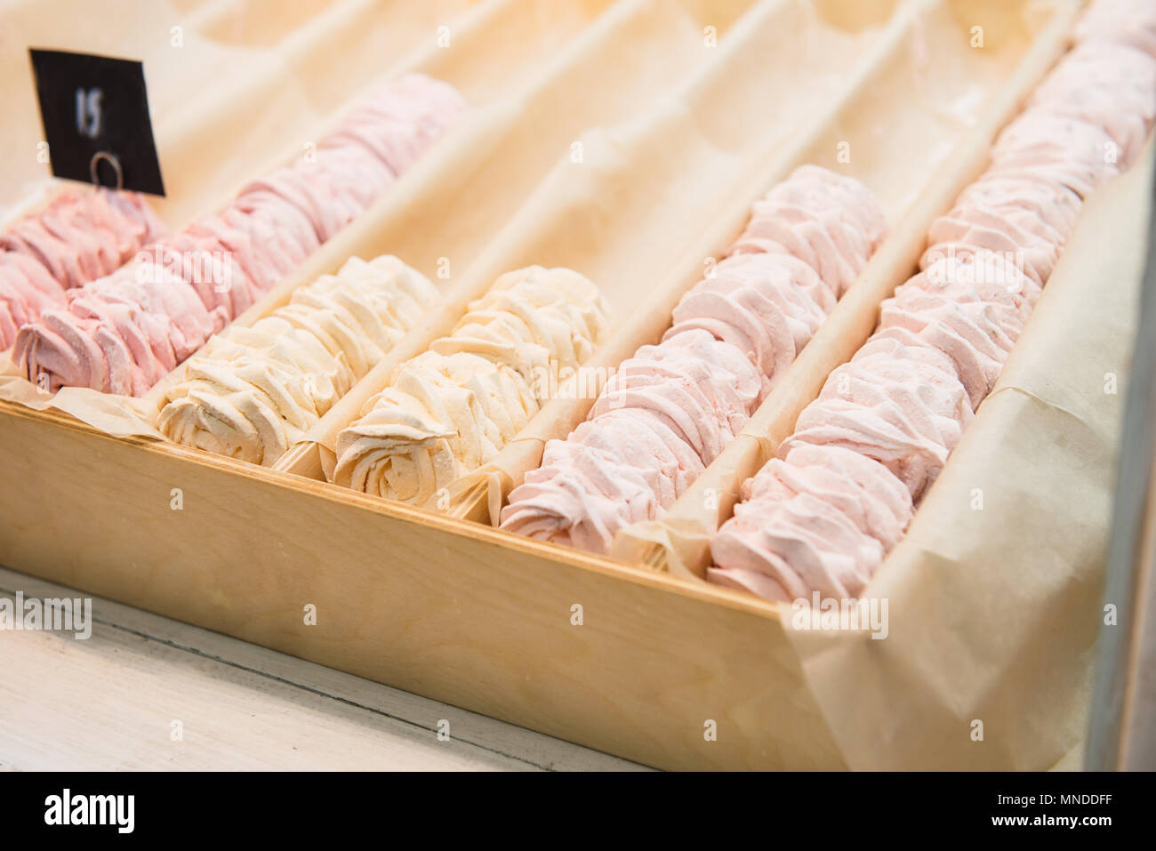 Pas plein de lignes de fruits guimauve rose et jaune, zephyr desserts dans un coffret en bois dans la boutique candy shop, café showcase. Soft focus sélectif. Space Banque D'Images