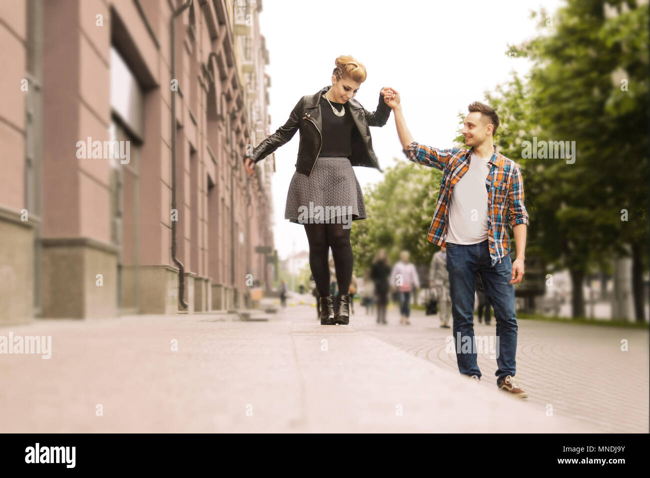 Concept d'amour:amour couple holding hands walking down the street Banque D'Images