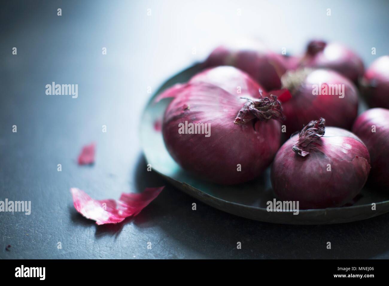 Oignons rouges sur une plaque Banque D'Images