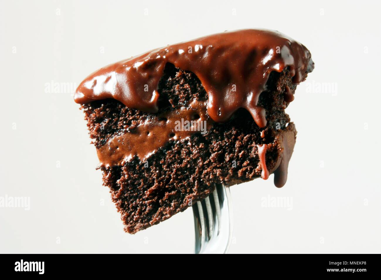Morceau de gâteau au chocolat avec glaçage au chocolat sur une fourchette Banque D'Images