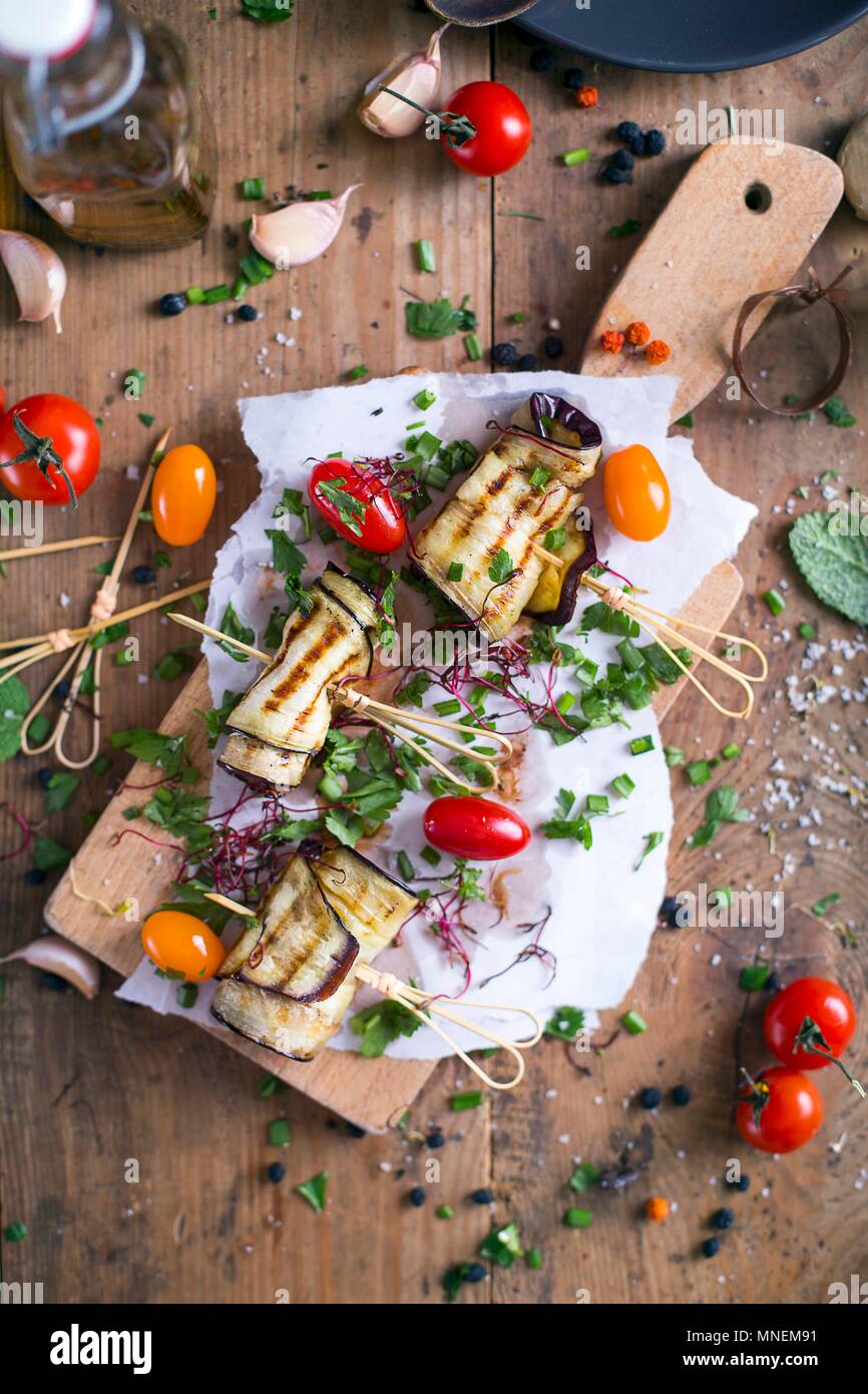 Aubergine grillée avec tomates et ciboulette sur une planche à découper Banque D'Images