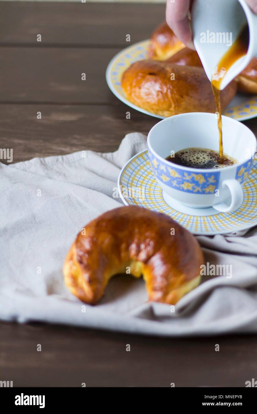 Noyer des pâtisseries en forme de croissant servi avec une tasse de café Banque D'Images