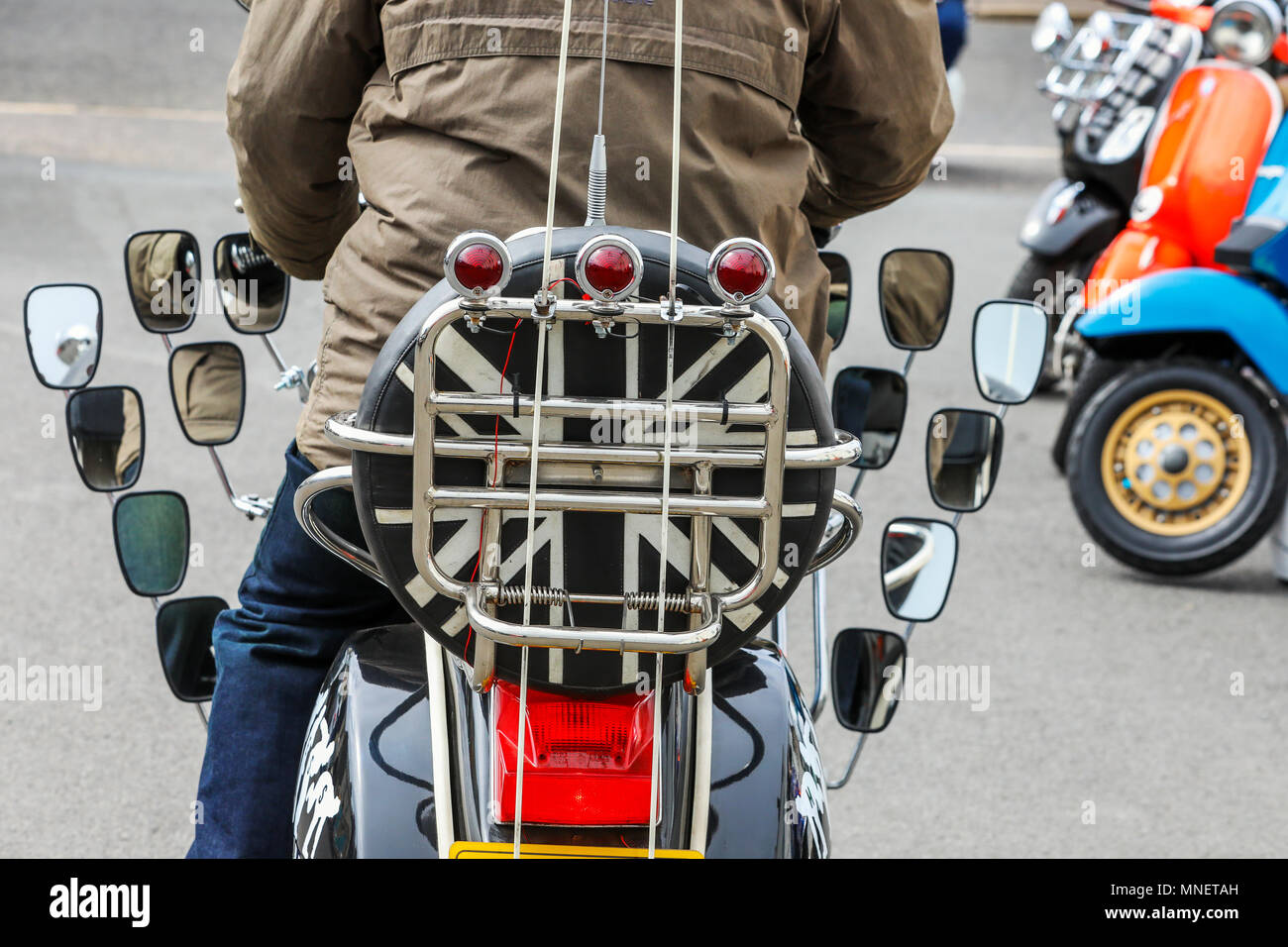 L'homme de la trottinette décorée avec de nombreux miroirs et d'un pneu de secours avec un noir et blanc du drapeau de l'Union européenne, le tout dans le style de mods de 1960 Banque D'Images