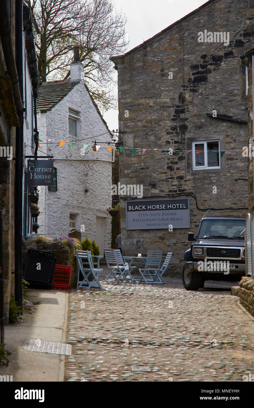 Un paisible coin de Grassington pavées et à l'extérieur avec chaises et tables et un signe pour th Black Horse Hotel. Nr Skipton, Yorkshire du Nord Banque D'Images