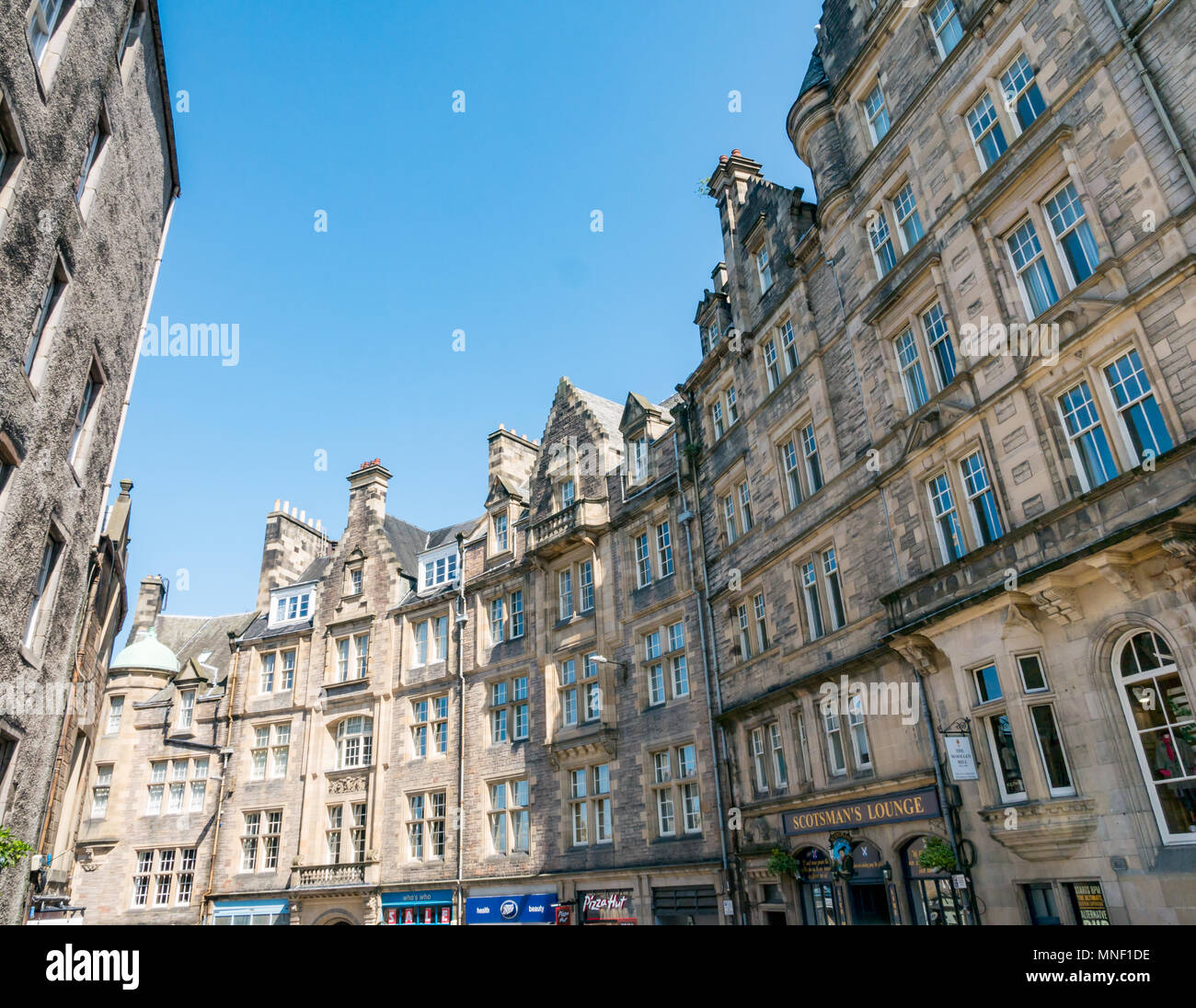 Grand immeuble vieux bâtiments en terrasses incurvé, Cockburn Street, le centre-ville d'Édimbourg, Écosse, Royaume-Uni, avec ciel bleu Banque D'Images