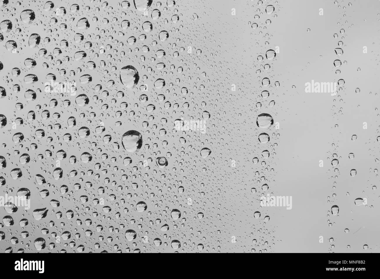 Gouttes de pluie la texture et la fenêtre en verre sur fond de ciel nuageux Banque D'Images