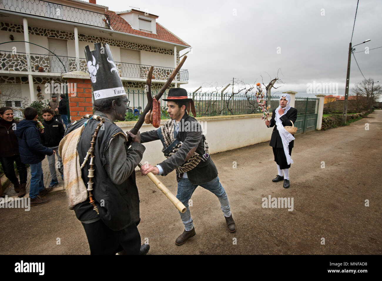 Le Farandulo personnage fait mal, essayant de peindre la fille de noir brûlé le liège. La fille est défendu par le garçon. Festivités du solstice d'hiver. Banque D'Images